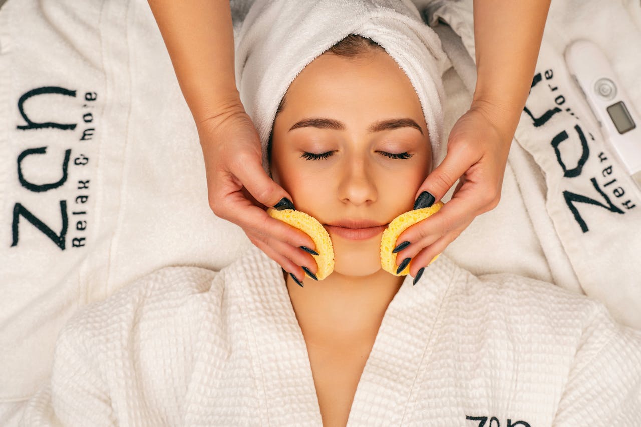 Woman receiving a soothing facial treatment in a spa setting, promoting wellness and relaxation.